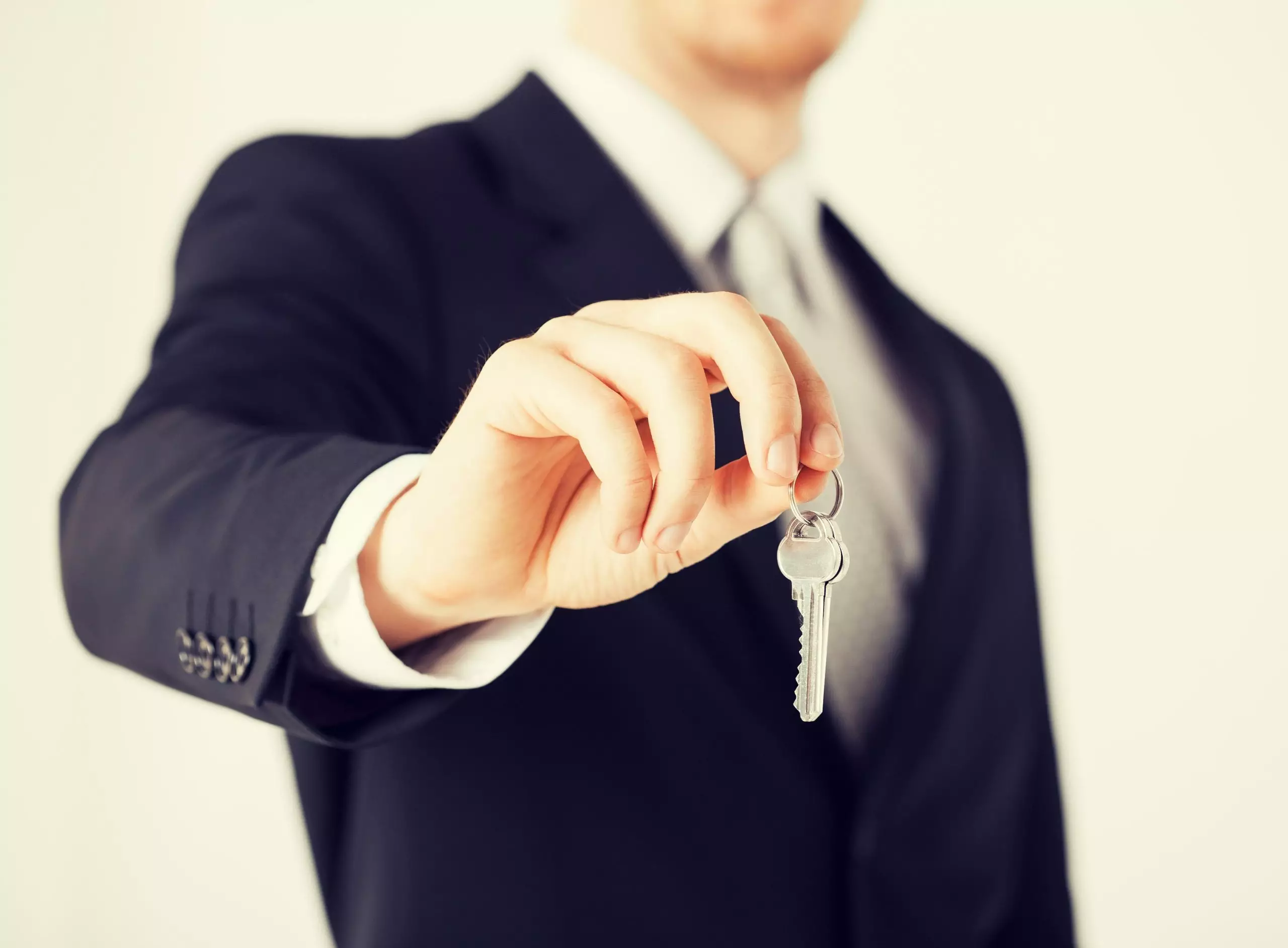 Man in black suit holding keys